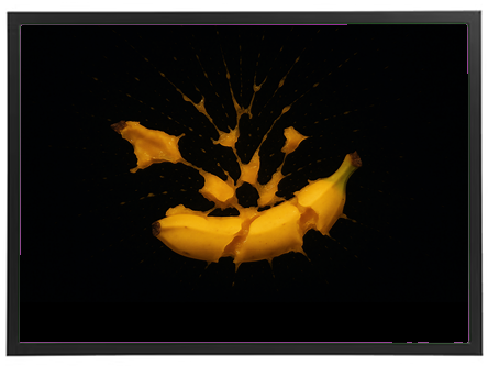 Et dramatisk billede af en banan, der splintres med sprøjtende væske mod en sort baggrund.