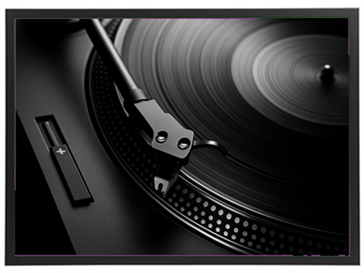 Et nærbillede af en stilfuld pladespiller med en drejende plade og tonearm.