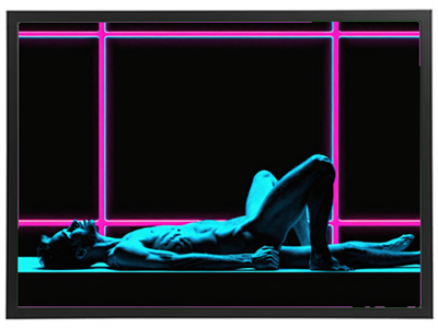 Billedet viser en mandlig figur liggende i en dramatisk neonbelyst scene.