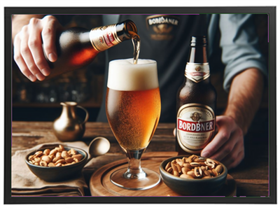 En person hælder øl i et glas, omgivet af snacks og en afslappet atmosfære.