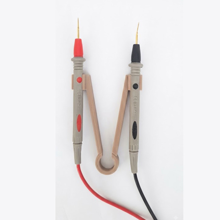 Multimeter Probe-Holder - Træt af at kæmpe med to løse prober, mens du prøver at aflæse et multimeter? Denne smarte, 3D-printede probe-holder fikserer dine testledninger i en fast afstand, så du nemt kan foretage målinger med én hånd. Det er det perfekte værktøj til teknikeren, hobby-elektrikeren eller elektronik-entusiasten, der vil arbejde mere effektivt og præcist. Holderen er kompakt, holdbar og gør din arbejdsstation meget mere overskuelig.