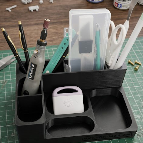 Hobby Organizer & Værktøjs Station - Giv dit kreative workspace en opgradering med denne alsidige og robuste hobby organizer, solidt 3D-printet i det ekstra slidstærke PETG-materiale. Designet er skræddersyet til hobbyister, modelbyggere og krea-entusiaster, der har brug for at holde orden på mange forskellige værktøjer i hverdagen.

Denne organizer har et gennemtænkt layout med flere dedikerede rum:

Dybere slots: Perfekte til præcisionsværktøj såsom mikroboremaskiner, hobbyknive, sakse og fine penne.

Mellemliggende sektioner: Velegnede til opbevaring af kasser med ekstra klinger, mindre værktøjsæsker eller andre mellemstore genstande.

Lave frontbakker: Ideelle til opbevaring af smådele, skruer, eller endda mindre elektroniske enheder som adaptere og USB-nøgler.

Takket være PETG-materialet får du en organizer, der tåler at blive brugt. Den er modstandsdygtig over for stød, ridser og de fleste væsker, hvilket gør den ideel til et aktivt værksted eller hobbyrum. Det kompakte og stabile design holder alt inden for rækkevidde og gør det nemt at rydde op på arbejdsbordet efter endt projekt.
