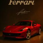 Rød Ferrari sportsvogn præsenteret med logo og signatur i baggrunden.