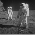 Astronauter på månen med Jorden synlig i baggrunden, taget under Apollo 11 missionen.